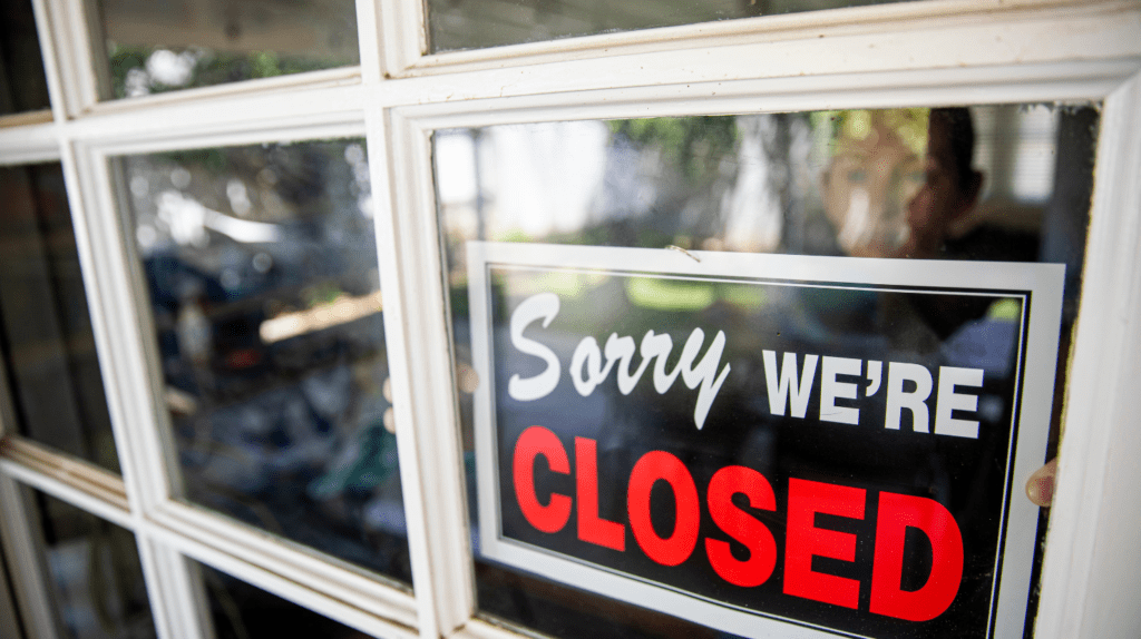 It's time to say goodbye. How to close your business. With a sign at a store saying "sorry, we're closed".